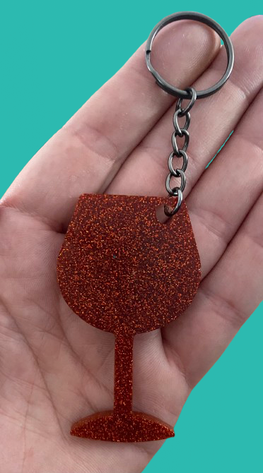 Hand holding wine glass key ring